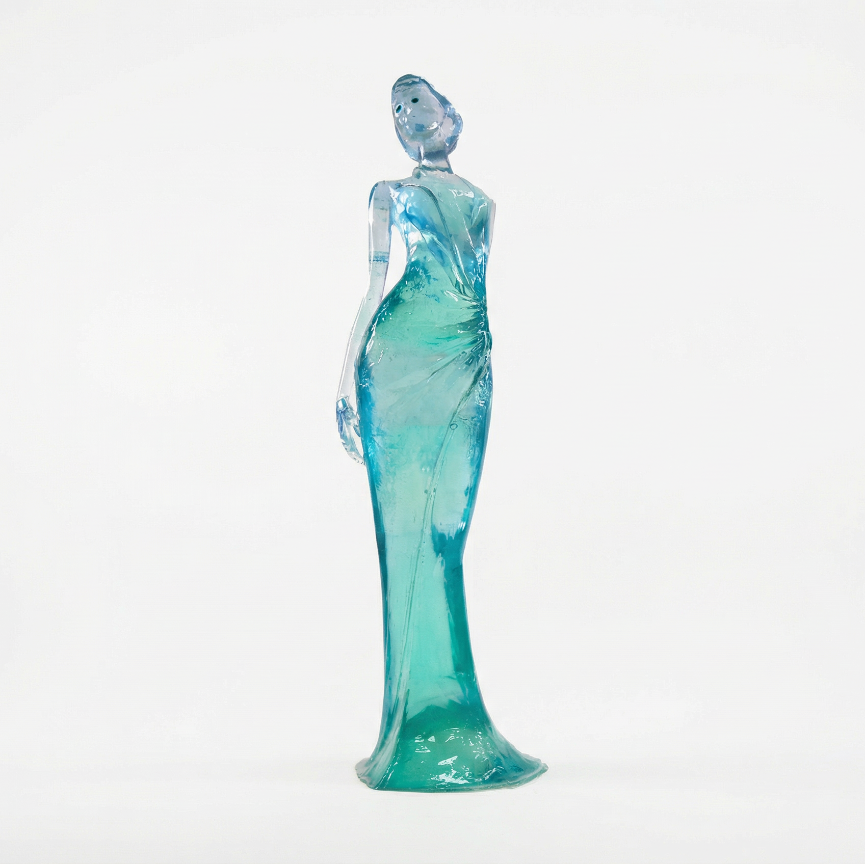 Glass figurine of a woman in a teal dress on a white background